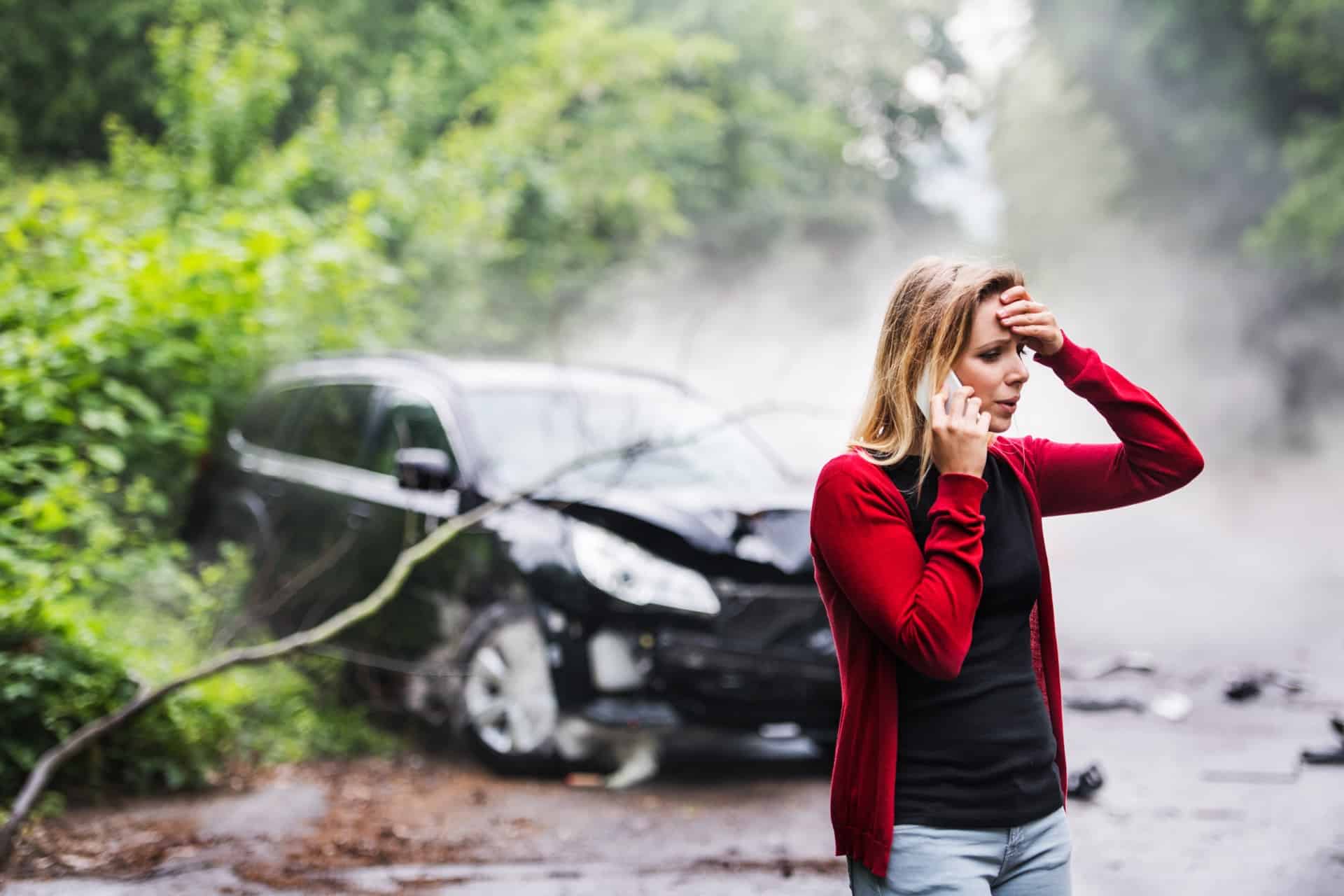 Woman with Smartphone and a Car Crashed in the Background