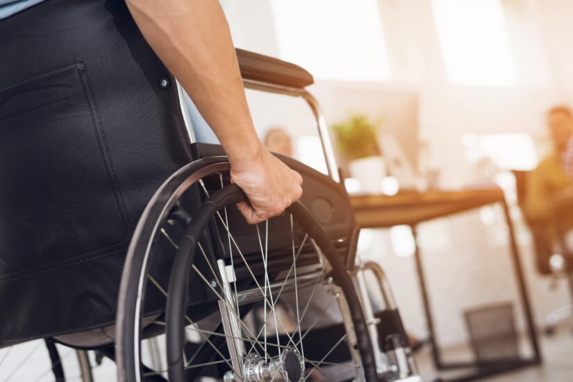 Person In A Wheelchair Holding His grip On A Wheelchairs Tire