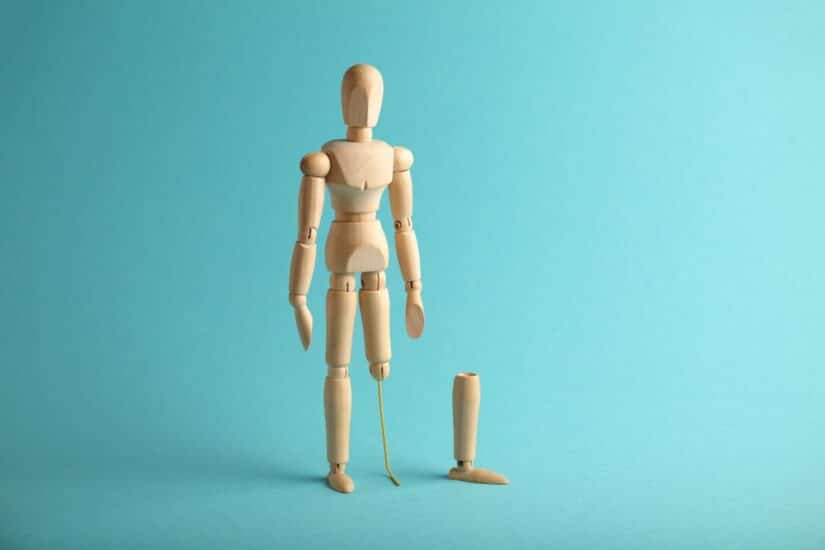 Wooden Mannequin Of A Person With One Of Its Legs Removed