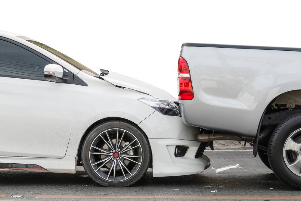 Car crash where a sedan has hit a truck from behind