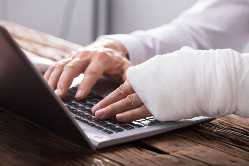 Photo of a Hand Injured Person Using Laptop