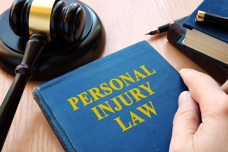 Personal Injury Law Book Next To Judges Hammer