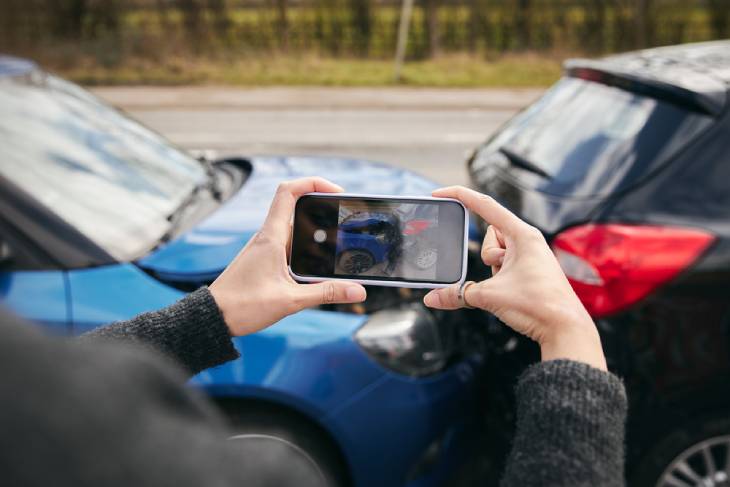 Man photographing car accident scene