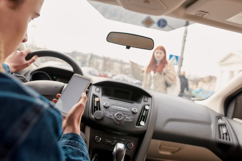 Driver Looking At His Phone About To Hit A Pedestrian