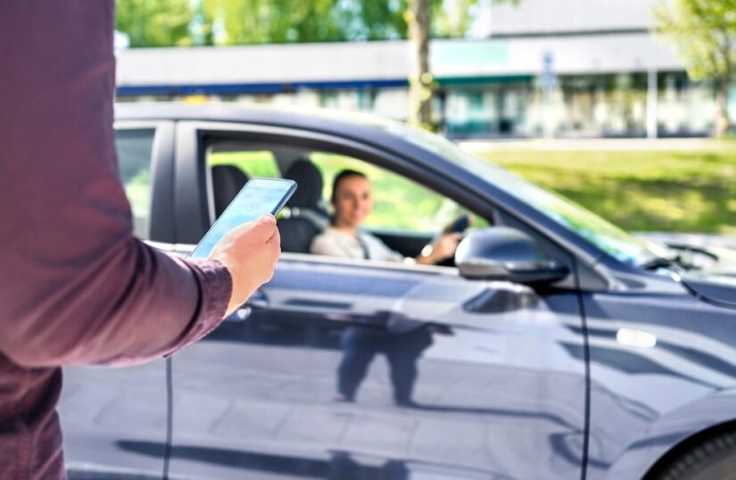 Client Looking At His Phone And A Car About To Pick Him Up