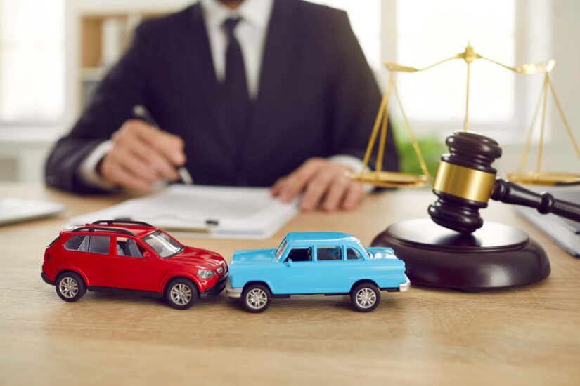 Two toy car models in the background of a judge who is conducting a lawsuit in a car accident